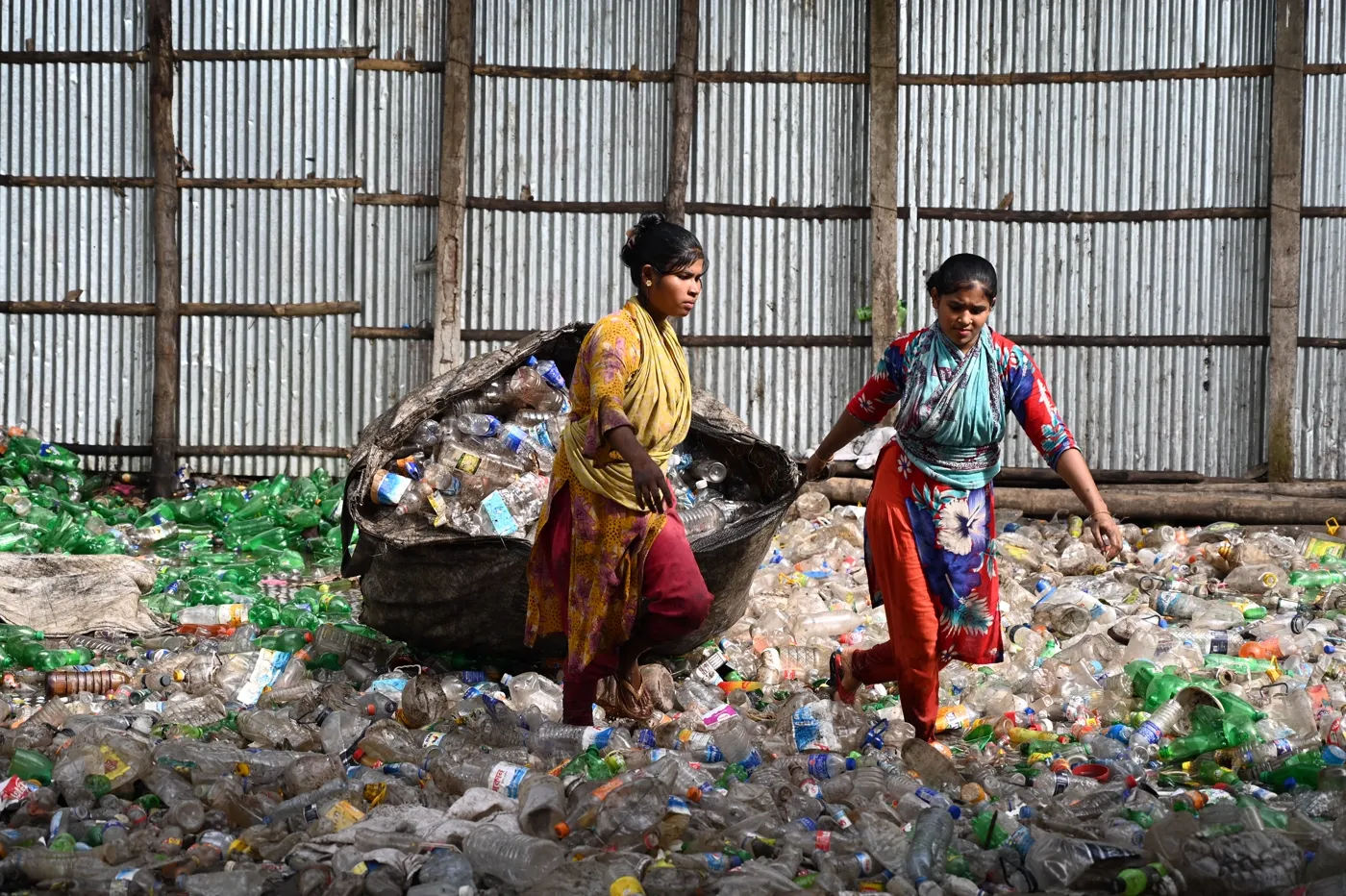 Workers sorting polymer scrap material at a recycling facility